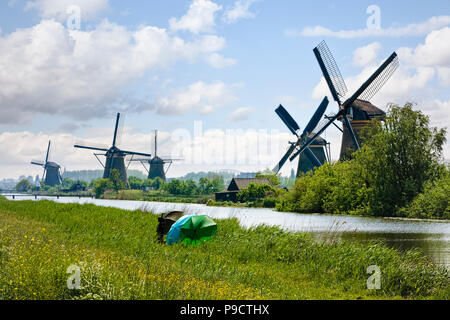 Fischer am Flussufer Neben den Windmühlen von Kinderdijk, Niederlande, Holland, Europa Stockfoto