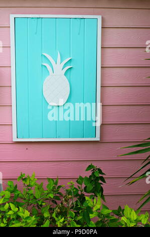 Farbenfrohe türkis Ananas Design auf rosa Holz- Gebäude in der Innenstadt von Marsh Harbour Island, Bahamas. Stockfoto