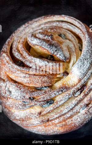 Cupcake Torte Crunch in Form einer Rolle bestreut mit Puderzucker auf einem dunklen Hintergrund und eine antike Gitter. Ostern und Weihnachten backen. Top vi. Stockfoto