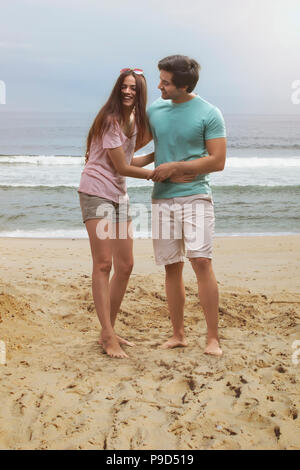 Junge Paare, die Spaß am Strand Stockfoto