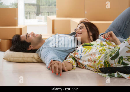 Junges Paar liegend auf dem Fußboden im Wohnzimmer. Stockfoto