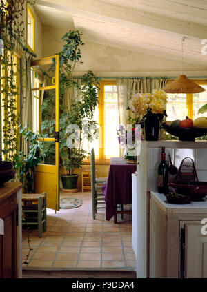 Terrakotta geflieste Boden im Wintergarten Wohnzimmer mit Korbstuhl