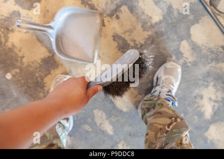Hand hält eine Hand Besen auf Bau Seite Stockfoto