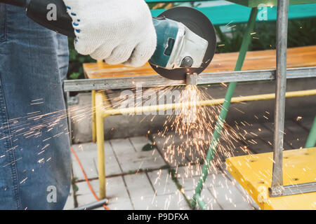 Das Metall wird durch eine Kette sah durch die Hand des Meisters. Stockfoto