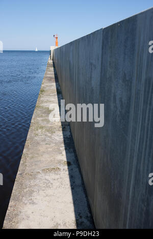 Der Leuchtturm auf dem Meer mit einem Boot auf dem Dam Stockfoto