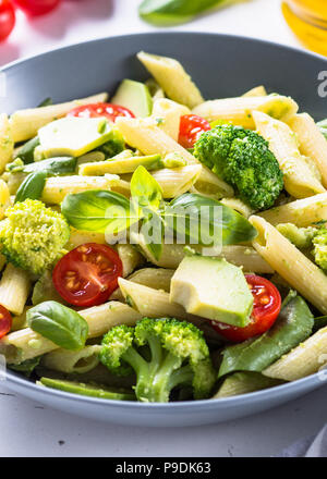 Vegetarische pasta Penne mit Avocado, Brokkoli, Tomaten, Spinat und Basilikum. Stockfoto