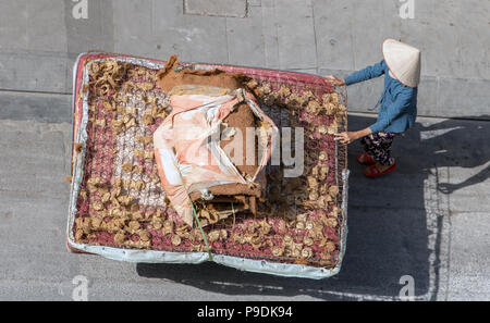 Vietnamesische Frau treibt einen Wagen mit großen alten Matratze. Das Leben auf der Straße an Saigon Stadt. Stockfoto