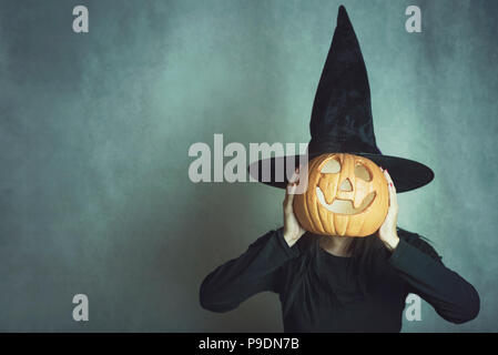 Junge Frau mit einem Kürbis für Halloween Stockfoto