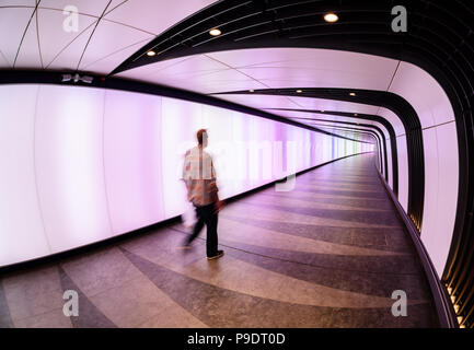 Menschen auf dem Weg in die beleuchteten Tunnel Anschluss von St Pancras und King's Cross Station in London. Stockfoto