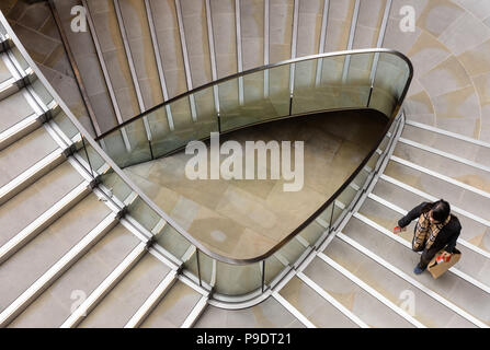 Frau, die einkaufstasche bis eine dreieckige Wendeltreppe in London Stockfoto