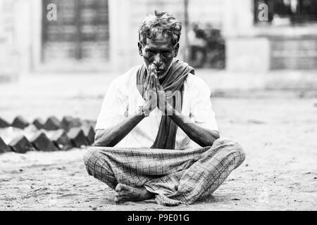 PUDUCHERY, PONDICHERRY, TAMI NADU, Indien - SEPTEMBER CIRCA, 2017. Ein unbekannter Mann sitzt mit gekreuzten Beinen und Händen meditieren vor einem Hindu Stockfoto