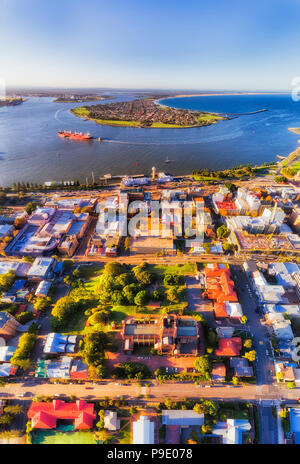 CBD der Stadt Newcastle um Kathedrale Kirche auf dem Hügel am Ufer des Hunter River Delta in den Pazifischen Ozean in Antenne vertikale Panorama von Grou Stockfoto