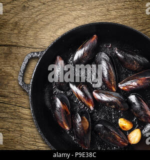 Pfanne mit gekochtem Muscheln auf Holz- Hintergrund Stockfoto