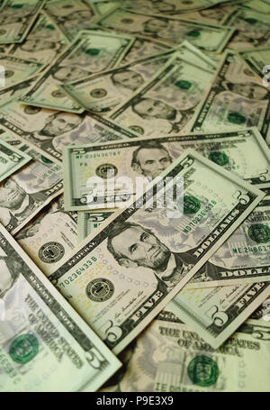Haufen der Vereinigten Staaten fünf Dollarscheine mit selektiven Fokus und unscharfen Hintergrund Stockfoto