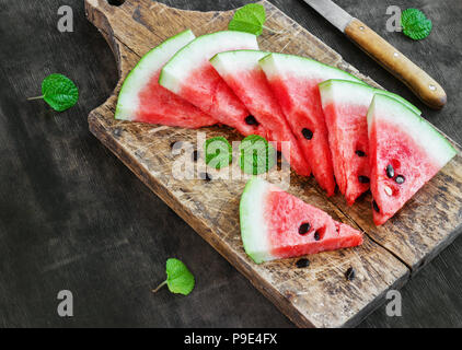 Frisch aufgeschnittenen Wassermelone auf einem alten Holz- Board, rustikalen Stil Stockfoto