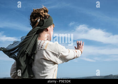 Junge Frau mit braunen Haaren und Dreadlocks tragen Kopftuch stehend auf einem Strand, Tai Chi. Stockfoto