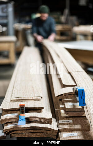 Ein Tischler in einer Holzwerkstatt sammeln Stücke Holz Furnier. Stockfoto