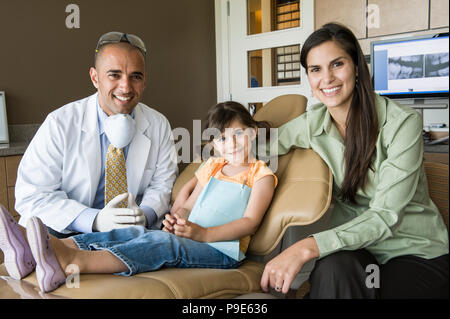 Das Porträt einer männlich Zahnarzt ein weibliches Kind Patienten und ihre Mutter in einer Zahnarztpraxis. Stockfoto