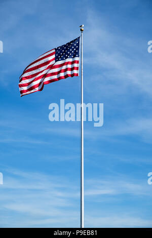 Amerikanische Flagge gehisst auf einem Mast mit negativen Raum und blauer Himmel Stockfoto