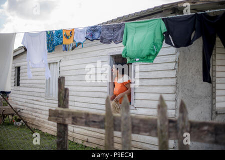 Eine Mutter lehnt sich aus dem Fenster ihrer Kinder zu nennen. Stockfoto