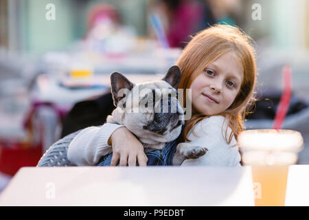 Schöne junge rothaarige Mädchen, dass adorable fawn Französische Bulldogge. Stockfoto