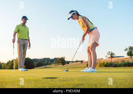 Die volle Länge einer Frau spielen professionelle Golf mit ihrem männlichen Partner Stockfoto