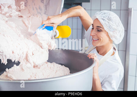 Frau in Wurstwaren, Hackfleisch arbeiten Stockfoto