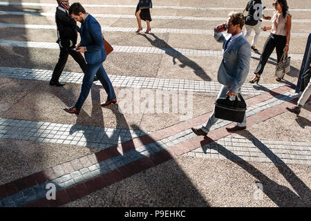 Geschäftsleute Pendeln zum Büro morgens Durchführung Büro Taschen und Mobiltelefone zu benutzen. Die Unternehmer und Unternehmerinnen in Eile aus zu erreichen. Stockfoto