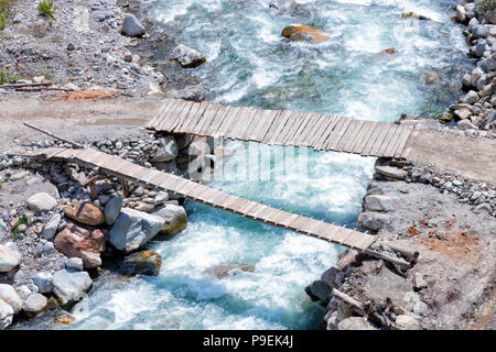 Blick von oben auf die beiden alten hölzernen Brücken über schnell fließenden Gebirgsfluss Stockfoto