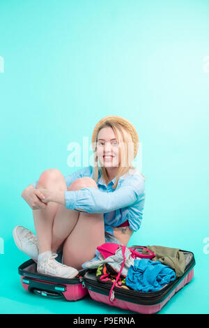 Freundliche Super Mädchen sitzen auf der geöffneten Koffer. in voller Länge Porträt Stockfoto