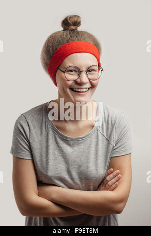 Charmante lachende Mädchen mit roten Stirnband auf ihrem flauschigen Haar. Stockfoto