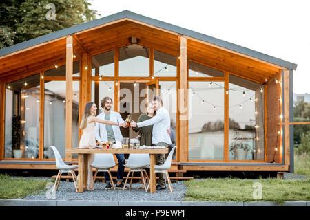 Freunde mit Getränken auf dem Hinterhof des Hauses Stockfoto