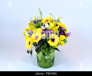 Berlin, Deutschland. 14 Mär, 2018. Ein bunter Blumenstrauß mit gelben Gerbera, Lilien und chrysanths, Blaue Distel, violett Eustoma, grüne Sweet William in eine grüne Vase. · Keine LEITUNG SERVICE · Credit: XAMAX/dpa/Alamy leben Nachrichten Stockfoto