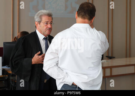 Deutschland, Ansbach. 18 Juli, 2018. Eine gefederte und warf Chief Inspector der Deutschen Polizei (R) spricht mit seinem Rechtsanwalt Reinhard Debernitz vor Beginn der Studie. Nach einer Fata Schießen von einem Polizisten durch einen 'Reichsbuerger' in Georgensgmuend, Oktober 2016 der 52-Jährige vor Gericht für Straftaten, die der arme Recht. Der Mann hatte angeblich privaten Kontakt mit "Personen Reichsbuerger" und nicht um eine private Pistole nach Spezifikationen zu speichern. Credit: Daniel Karmann/dpa/Alamy leben Nachrichten Stockfoto