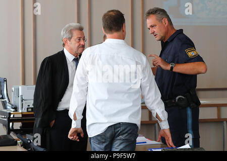 Deutschland, Ansbach. 18 Juli, 2018. Eine gefederte und warf Chief Inspector der Deutschen Polizei (C) spricht mit seinem Rechtsanwalt Reinhard Debernitz und einem Kollegen vor Beginn der Studie. Nach einer Fata Schießen von einem Polizisten durch einen 'Reichsbuerger' in Georgensgmuend, Oktober 2016 der 52-Jährige vor Gericht für Straftaten, die der arme Recht. Der Mann hatte angeblich privaten Kontakt mit "Personen Reichsbuerger" und nicht um eine private Pistole nach Spezifikationen zu speichern. Credit: Daniel Karmann/dpa/Alamy leben Nachrichten Stockfoto