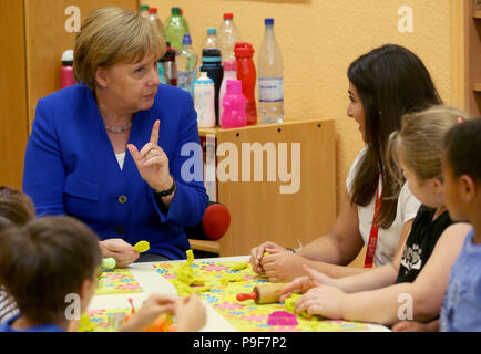 Deutschland, Köln. 18 Juli, 2018. Die deutsche Bundeskanzlerin Angela Merkel (CDU) besucht die Caritas Zentrum Kalk und begleitet die Kinder während Ihrer kreativen Selbstausdruck. Credit: Oliver Berg/dpa/Alamy leben Nachrichten Stockfoto