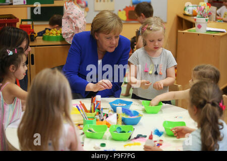 Deutschland, Köln. 18 Juli, 2018. Die deutsche Bundeskanzlerin Angela Merkel (CDU) besucht die Caritas Zentrum Kalk und begleitet die Kinder während Ihrer kreativen Selbstausdruck. Credit: Oliver Berg/dpa/Alamy leben Nachrichten Stockfoto