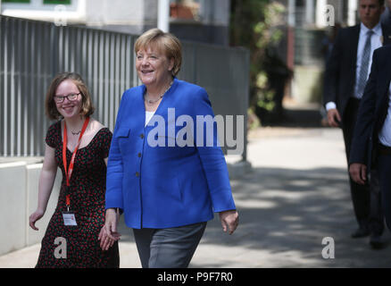 Deutschland, Köln. 18 Juli, 2018. Die deutsche Bundeskanzlerin Angela Merkel (L, CDU) besucht das Caritas Zentrum Kalk und ist von Natalie Dedreux (C) begrüßt. Das Mädchen mit Down Syndrom forderte die Kanzlerin eine Frage während der Wahlkampagne in Bezug auf das Recht auf Schwangerschaftsabbruch. Credit: Oliver Berg/dpa/Alamy leben Nachrichten Stockfoto