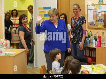 Deutschland, Köln. 18 Juli, 2018. Die deutsche Bundeskanzlerin Angela Merkel (CDU) besucht die Caritas Zentrum Kalk und begleitet die Kinder während Ihrer kreativen Selbstausdruck. Credit: Oliver Berg/dpa/Alamy leben Nachrichten Stockfoto