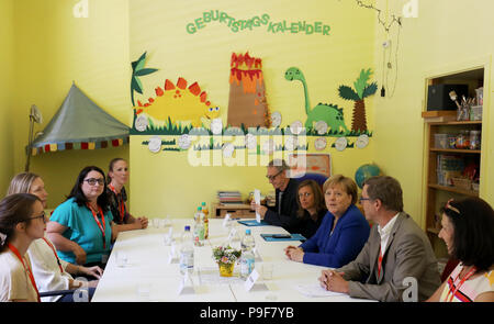 Deutschland, Köln. 18 Juli, 2018. Die deutsche Bundeskanzlerin Angela Merkel (3-R, CDU) besucht das Caritas Zentrum Kalk und spricht mit Eltern und Lehrern. Credit: Oliver Berg/dpa Pool/dpa/Alamy leben Nachrichten Stockfoto