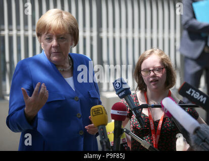 Deutschland, Köln. 18 Juli, 2018. Die deutsche Bundeskanzlerin Angela Merkel (L, CDU) liefert eine Aussage mit Natalie Dedreux nach dem Besuch im Caritas Zentrum in Kalk. Das Mädchen mit Down Syndrom forderte die Kanzlerin eine Frage während der Wahlkampagne in Bezug auf das Recht auf Schwangerschaftsabbruch. Credit: Oliver Berg/dpa/Alamy leben Nachrichten Stockfoto