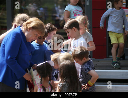 Deutschland, Köln. 18 Juli, 2018. Die deutsche Bundeskanzlerin Angela Merkel (CDU) besucht die Caritas Zentrum Kalk und erhält ein Self-made Buch aus zahlreichen Kinder. Credit: Oliver Berg/dpa/Alamy leben Nachrichten Stockfoto