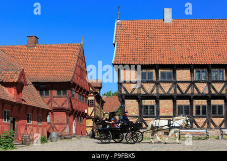 Eine Kutschenfahrt mit Touristen am Hauptplatz der Open-air Museum der Stadt Den Gamle By in Århus, Dänemark Stockfoto