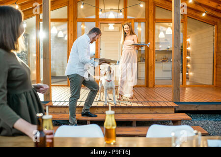 Freunde die Vorbereitung für das Abendessen in der Nähe des Hauses Stockfoto