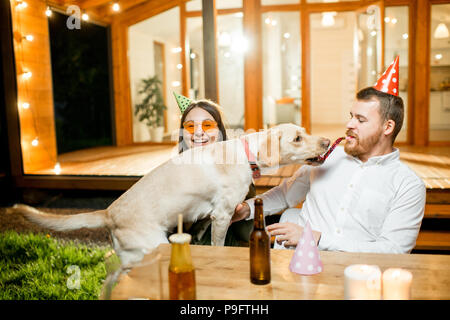 Hund mit Paar auf dem Hinterhof des Hauses Stockfoto