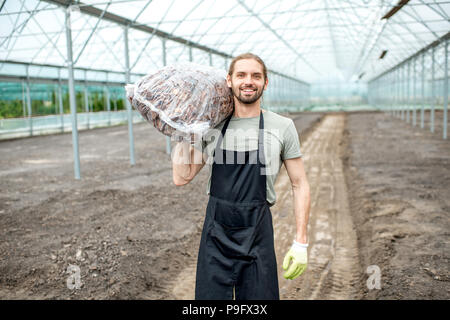 Landwirt mit Tasche im Gewächshaus Stockfoto