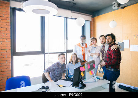 Foto von wunderschöne junge startup Team auf die Kamera in der Loft office posieren. super multi-ethnische junge Menschen bei der Arbeit Stockfoto