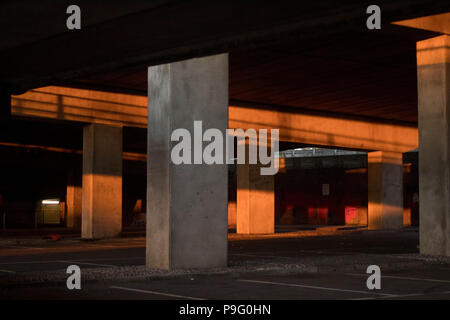 Urban Decay - residuale Sonnenlicht & Farbe in einen leeren Parkplatz unter einer Überführung. Essex, Großbritannien. Stockfoto