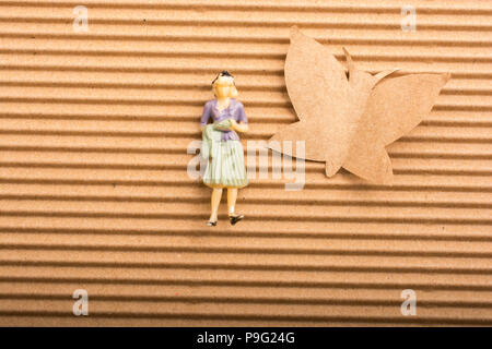 Frau Figur platziert neben einem Papier Schmetterling Form Stockfoto