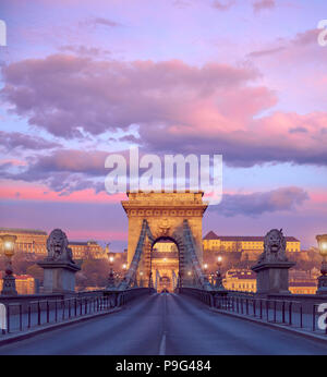 Budapester Burg und der berühmten Kettenbrücke in Budapest auf einen Sonnenaufgang. Konzentrieren Sie sich auf die Brücke. Stockfoto